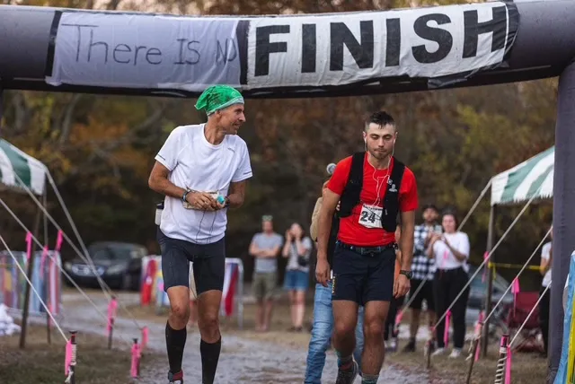 Harvey Lewis wearing his signature bandana celebrating at the race arch