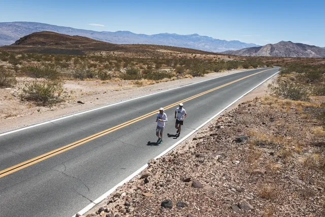 Harvey Lewis and pacer striding down a two-lane Death Valley highway