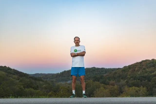 Harvey Lewis portrait at sunset on a quiet road overlooking wooded hills